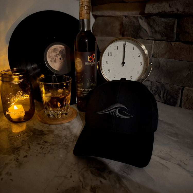 Midnight Edition Richardson R225 Hat with a clock set to midnight, a glass of bourbon, a Midnight Symphony liquire bottle and a candle.