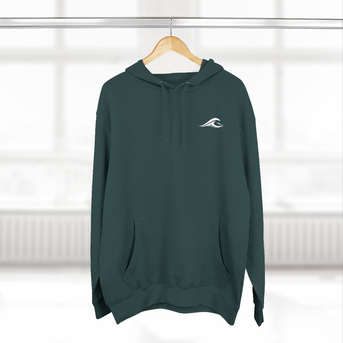 FLOWAV Coastal Graphic Hoodie in sports green hanging on a wooden hanger showing the front wave logo