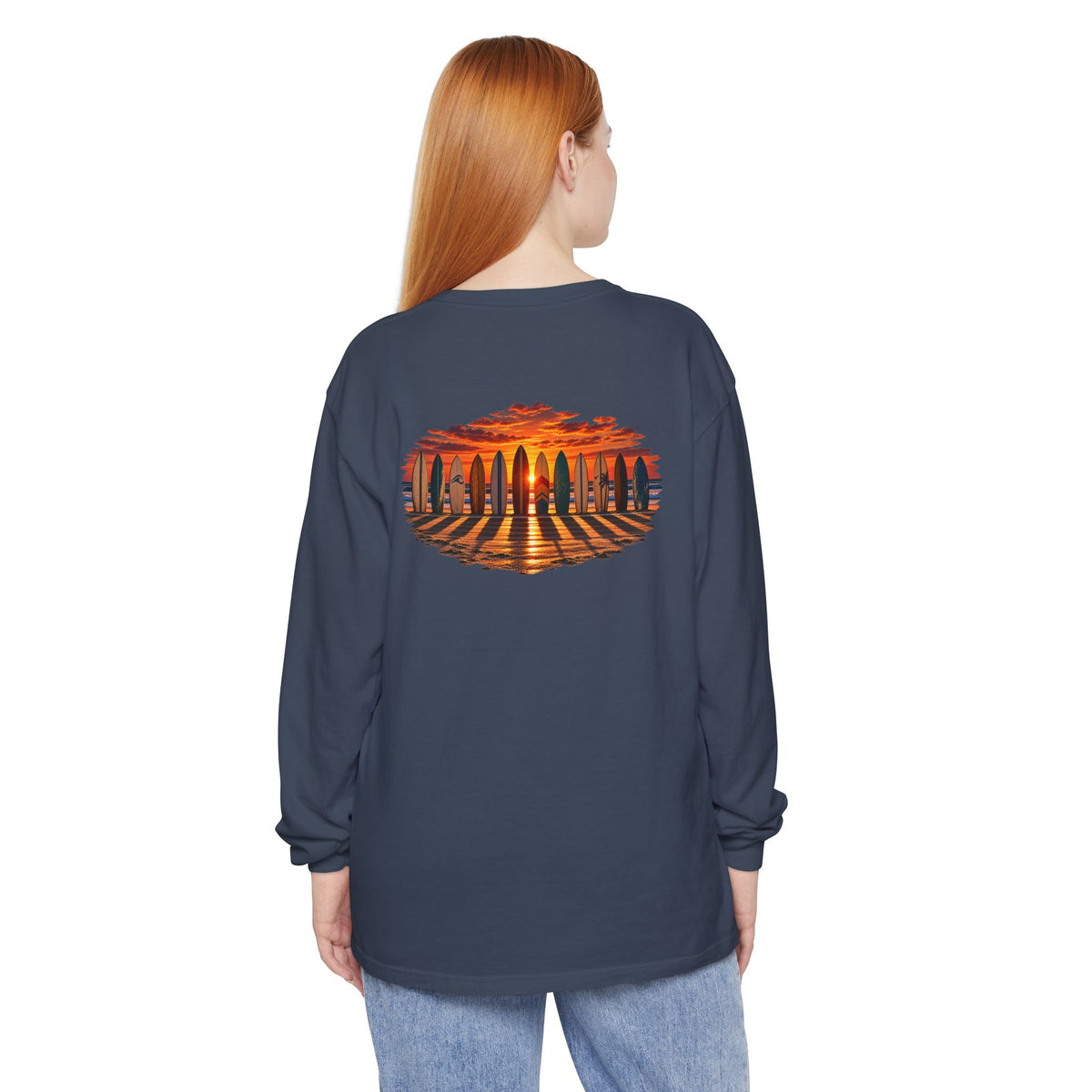 Woman wearing the FLOWAV Coastal Sunset Long Sleeve Tee in midnight showing the back surfboard and piano keys at sunset