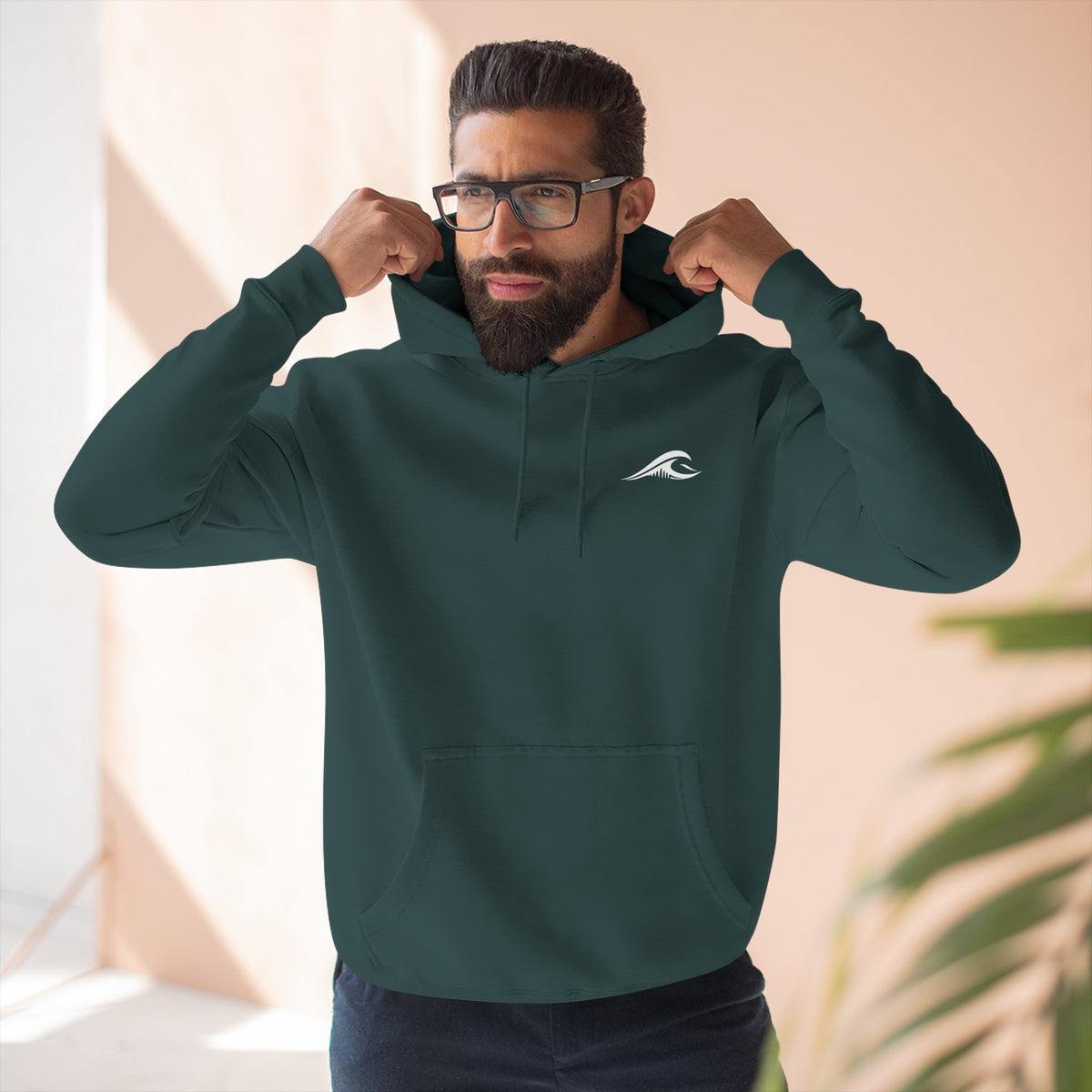 Man wearing the FLOWAV Coastal Graphic Hoodie in sports green showing the front wave logo on the left chest.