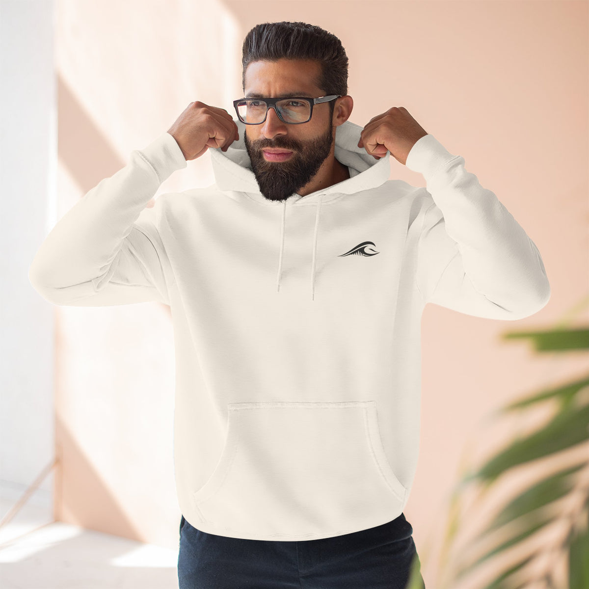 Man wearing the FLOWAV Coastal Graphic Hoodie in sandshell showing the front wave logo on the left chest.