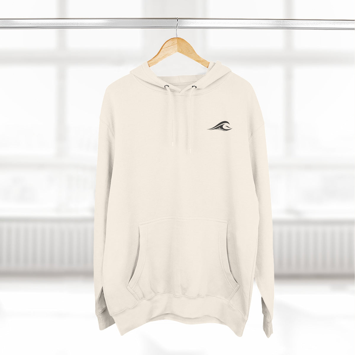FLOWAV Coastal Graphic Hoodie in sandshell hanging on a wooden hanger showing the front wave logo