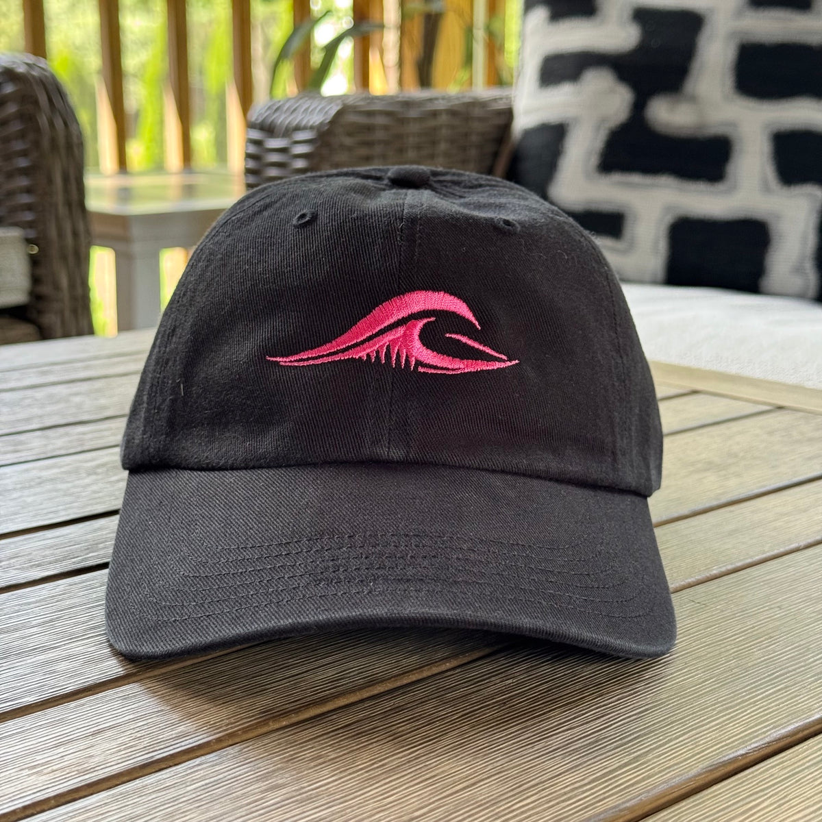 FLOWAV Pink Edition Richardson R55 classic dad hat showing the front pink embroidered wave resting on a wooden table outside