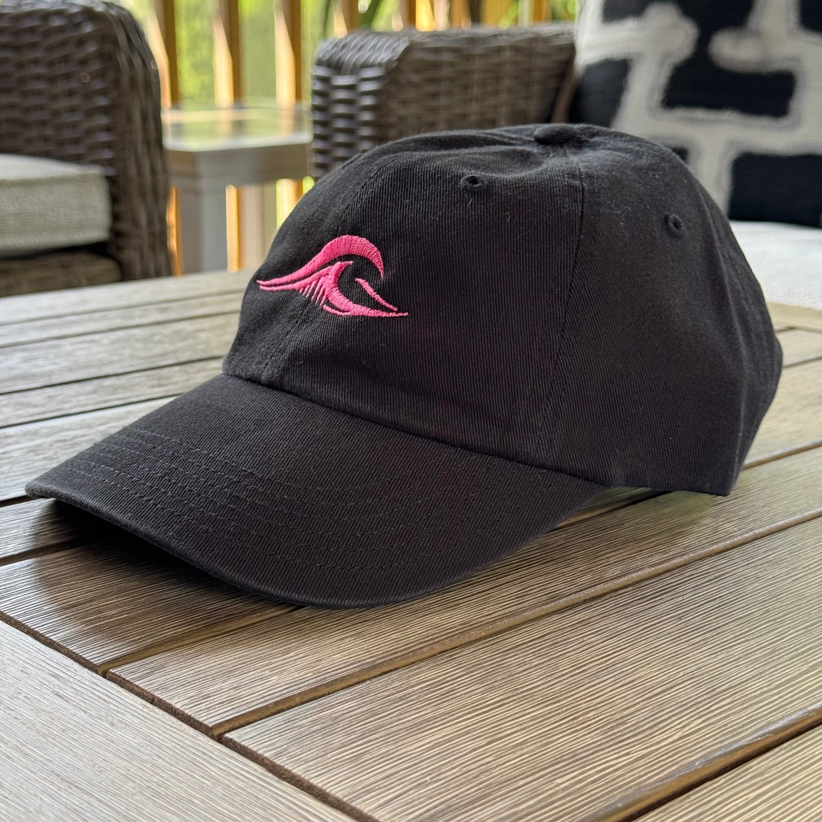 FLOWAV Pink Edition Richardson R55 classic dad hat showing an angled view of the pink wave resting on a wooden table.
