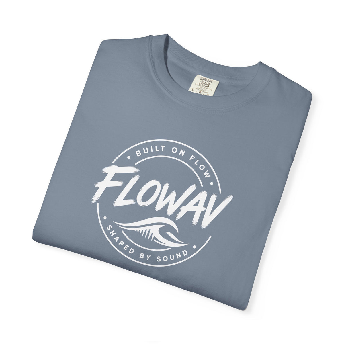 A folded FLOWAV Badge Tee in blue jean featuring built on flow shaped on sound slogan and a white wave logo.