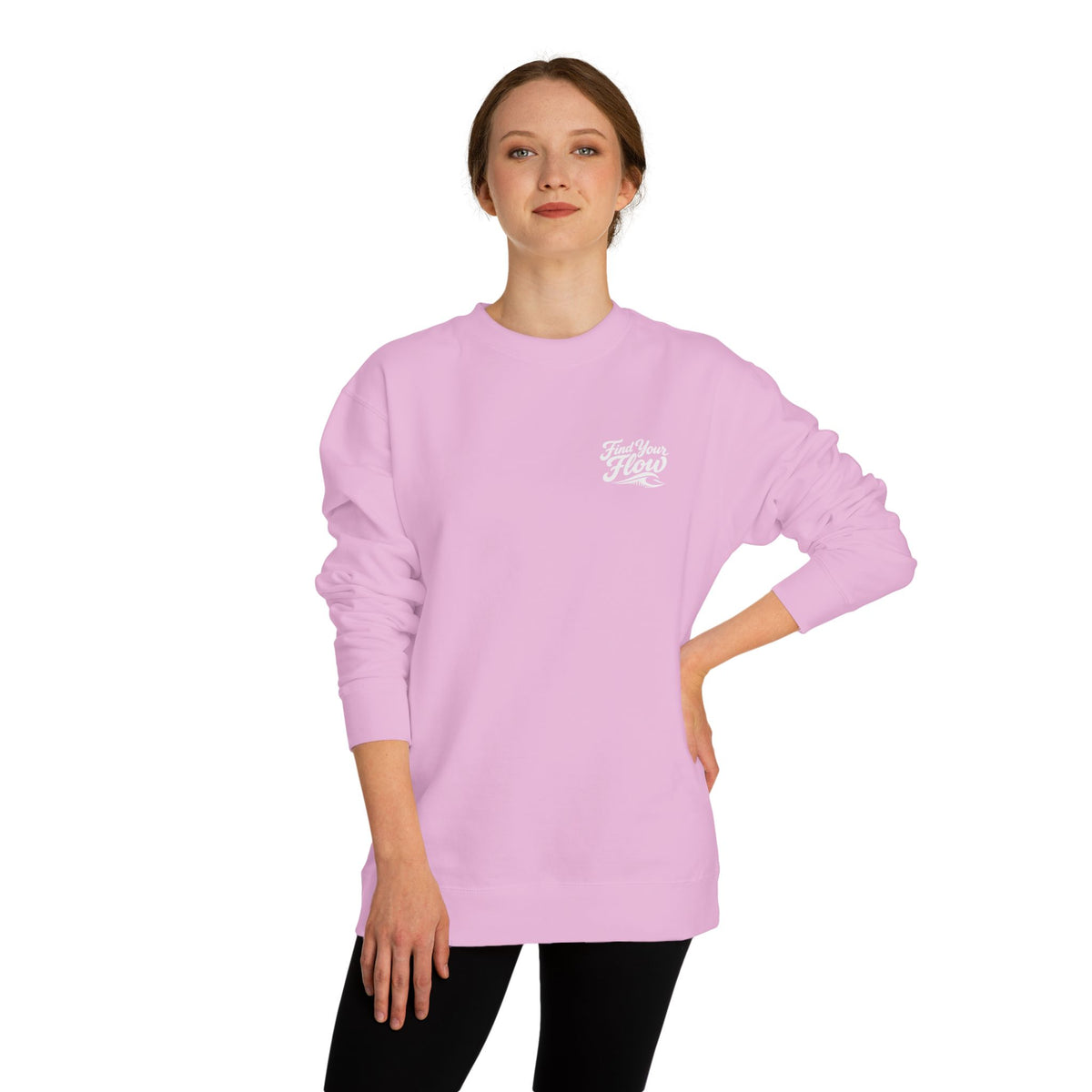 A woman wearing a FLOWAV Find Your Flow crewneck sweatshirt in light pink showing the front graphic and wave detail.