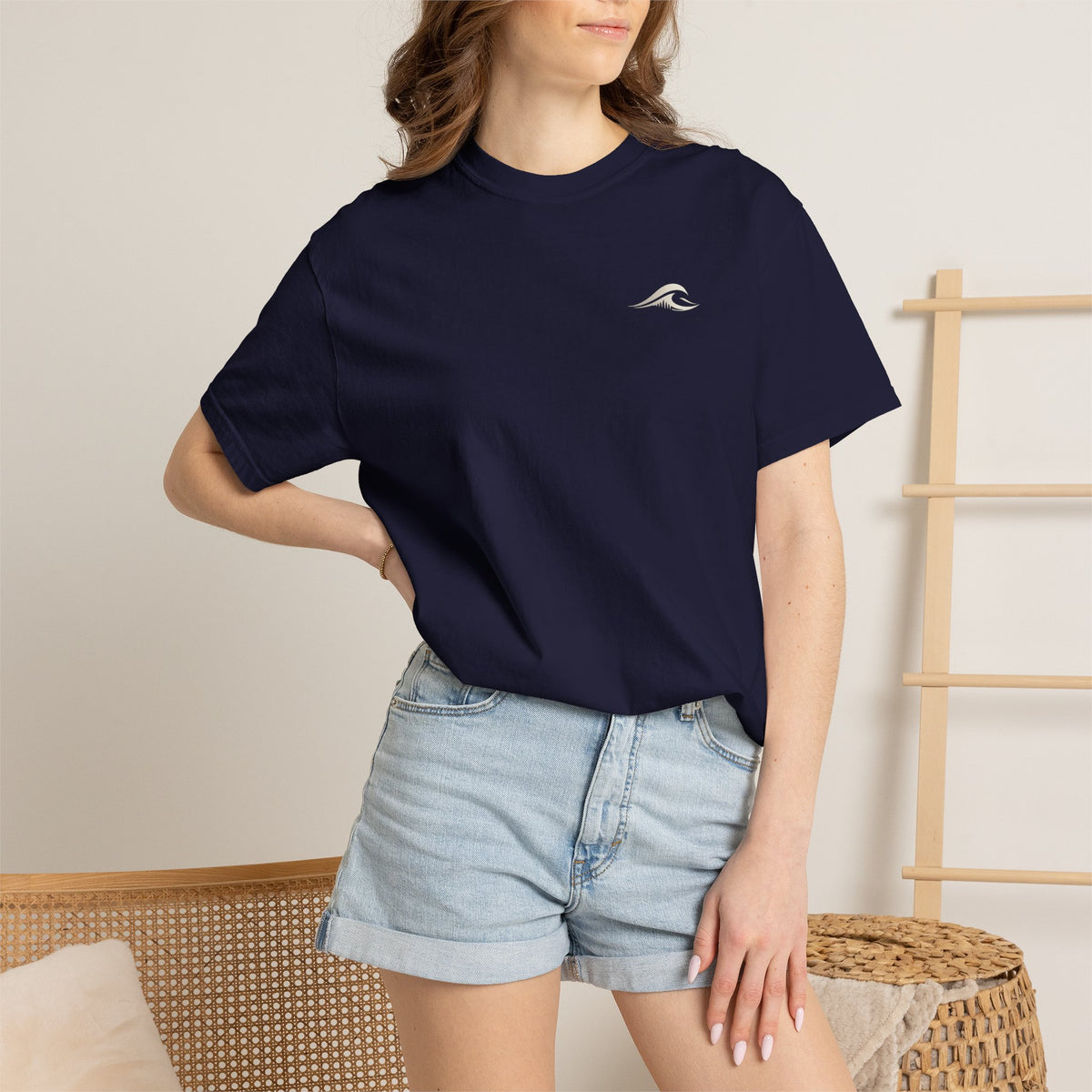 A woman wearing the FLOWAV Midnight Edition Graphic Tee in True Navy showing the front FLOWAV wave logo.