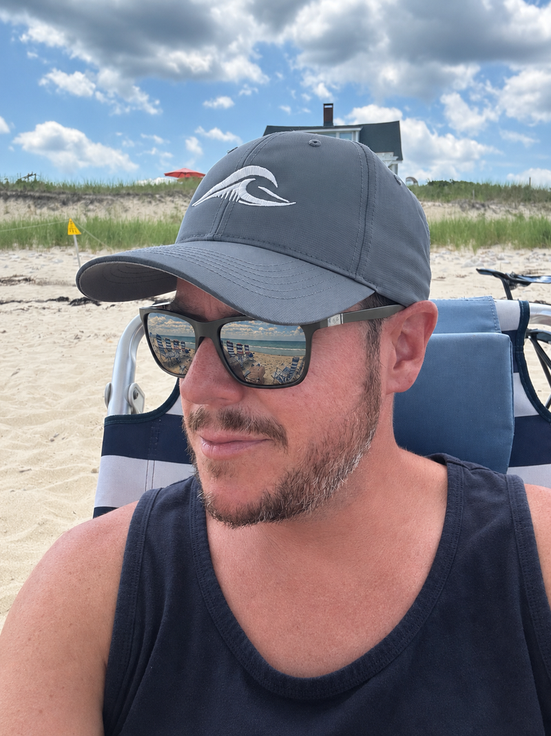 Person wearing a FLOWAV Richardson R225 Performance Hat while relaxing at the beach on a sunny day.