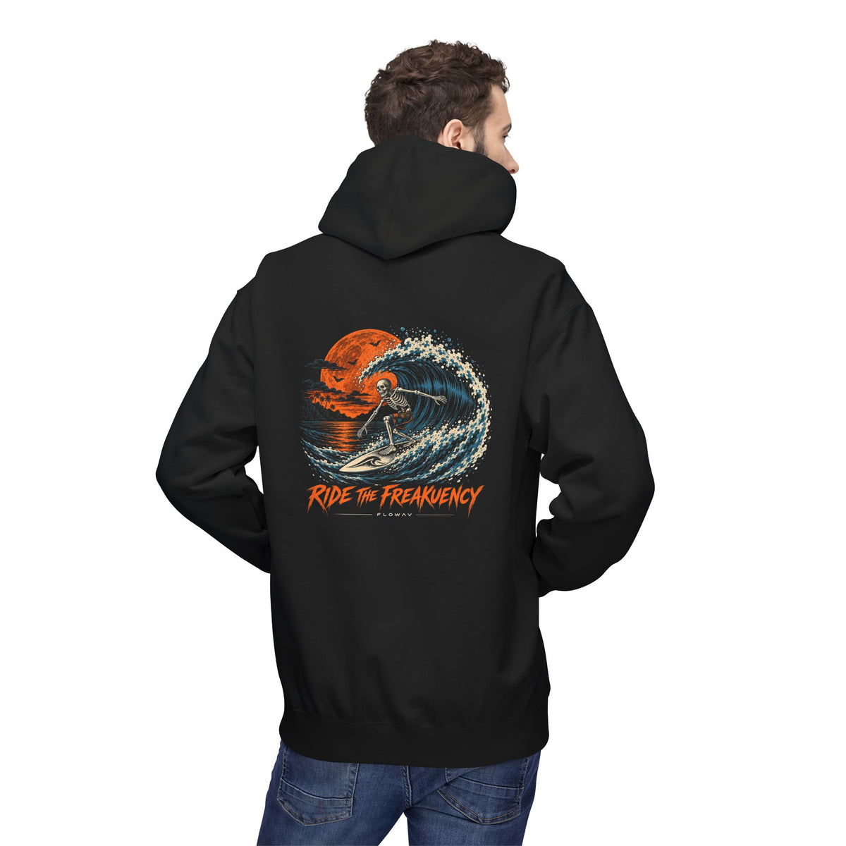 A man wearing a FLOWAV Ride the Freakuency Graphic Hoodie in black with a skeleton surfing and an orange moon