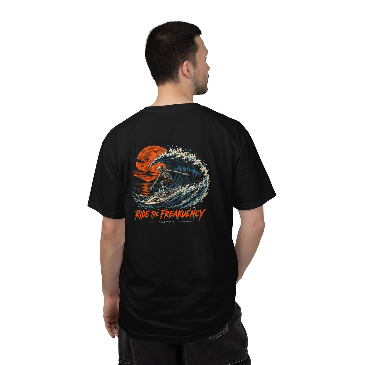 Man wearing the FLOWAV Ride the Freakuency Graphic Tee in black showing the back graphic of a skeleton surfer and orange moon