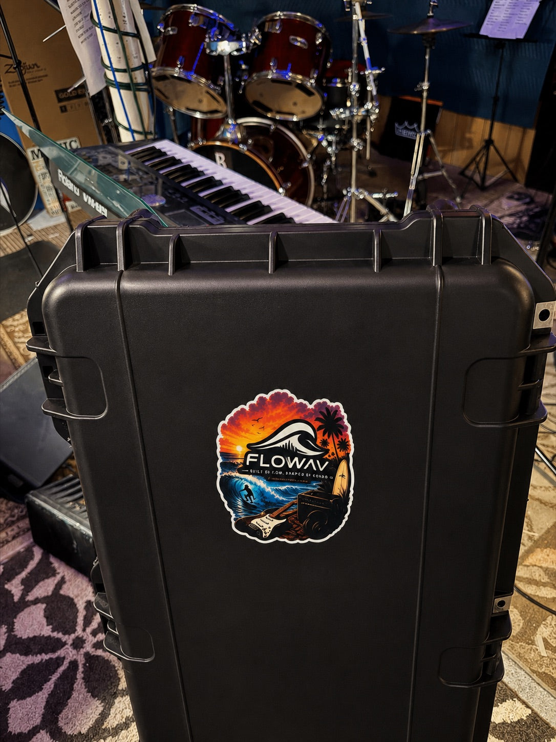 FLOWAV Sunset Sticker applied to a black keyboard equipment case in a music studio